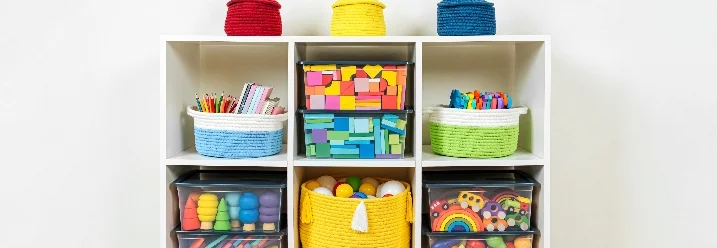 Weißes Regal mit bunten Spielzeugkörben